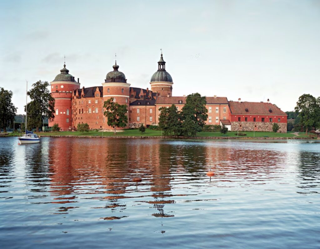 water surrounding a large brick building reflected in it